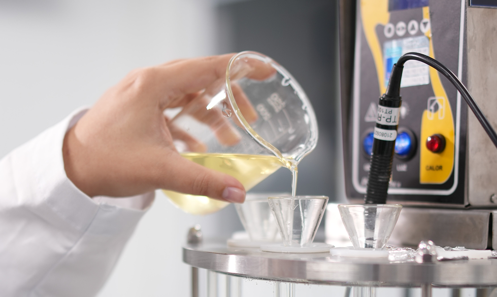 Hand pouring liquid into beakers