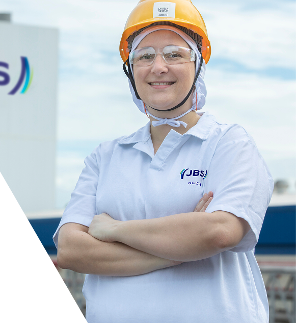JBS employee smiling while wearing a yellow hard hat and safety glasses.